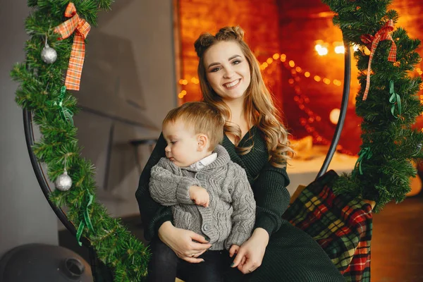 Jolie famille assise près du sapin de Noël — Photo