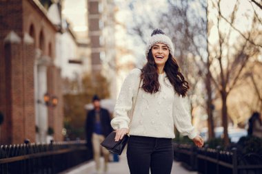 Şehirde beyaz kazak giyen tatlı bir esmer.