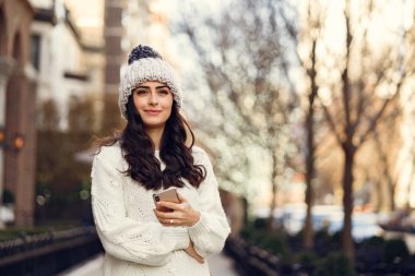Şehirde beyaz kazak giyen tatlı bir esmer.
