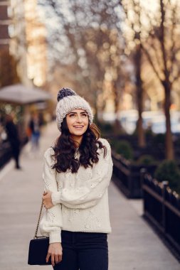 Şehirde beyaz kazak giyen tatlı bir esmer.
