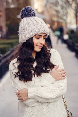 Şehirde beyaz kazak giyen tatlı bir esmer.