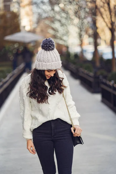 Roztomilá brunetka v bílém svetru ve městě — Stock fotografie