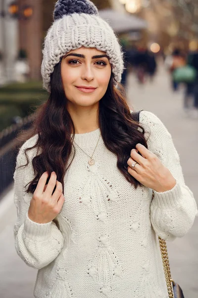 Leuke brunette in een witte trui in een stad — Stockfoto