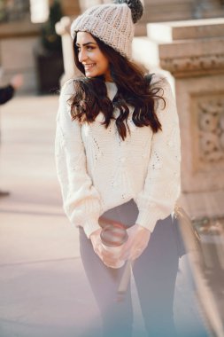 Şehirde beyaz kazak giyen tatlı bir esmer.