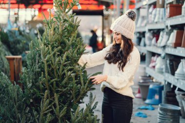 Beyaz süveter ve Noel ağacı içinde tatlı bir esmer.