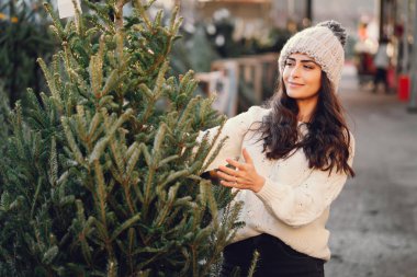 Beyaz süveter ve Noel ağacı içinde tatlı bir esmer.