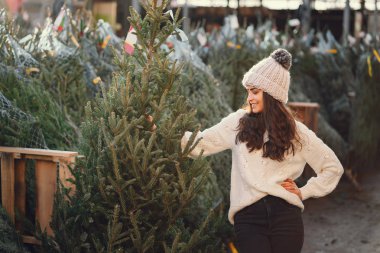 Beyaz süveter ve Noel ağacı içinde tatlı bir esmer.
