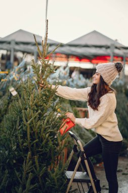 Beyaz süveter ve Noel ağacı içinde tatlı bir esmer.
