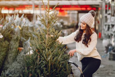 Beyaz süveter ve Noel ağacı içinde tatlı bir esmer.