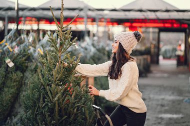 Beyaz süveter ve Noel ağacı içinde tatlı bir esmer.