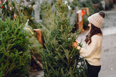 Beyaz süveter ve Noel ağacı içinde tatlı bir esmer.
