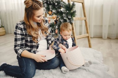 Noel ağacının yanında oturan sevimli bir aile.