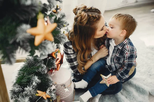 Linda familia sentada cerca del árbol de Navidad — Foto de Stock