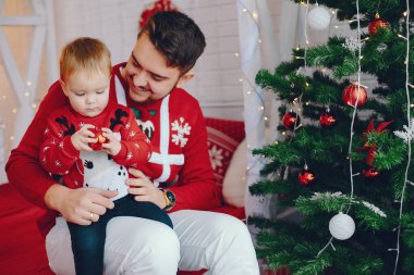 Noel ağacının yanında oturan sevimli bir aile.