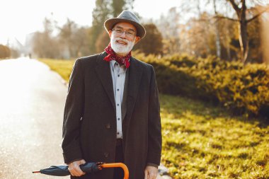 Güneşli bir sonbahar parkta zarif yaşlı adam 