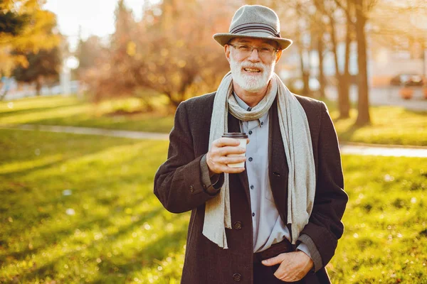 Vieil homme élégant dans un parc d'automne ensoleillé — Photo