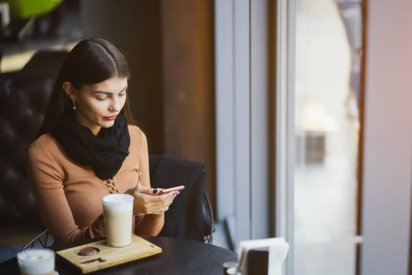 Esmer kız restoranda telefon kullanıyor. — Stok fotoğraf