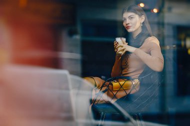 esmer kız bir restoranda sıcak bir içecek içme