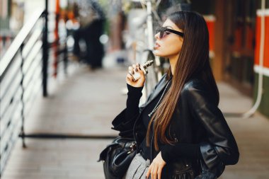 Şık bir kız e-sigara içiyor.