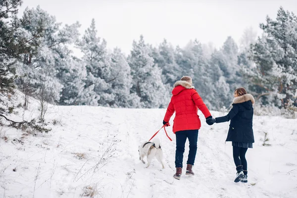 Belo casal brincando com um cão — Fotografia de Stock