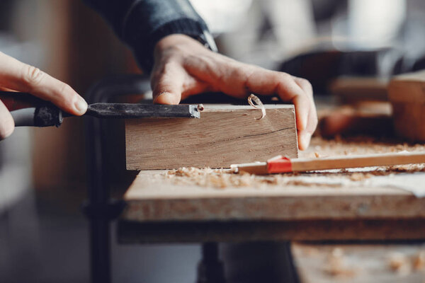 The carpenter works with a tree