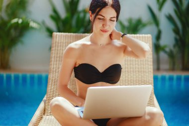 Havuz kenarında çalışan esmer kız.