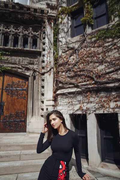 Elegante morena de pie junto a la entanza de un edificio —  Fotos de Stock