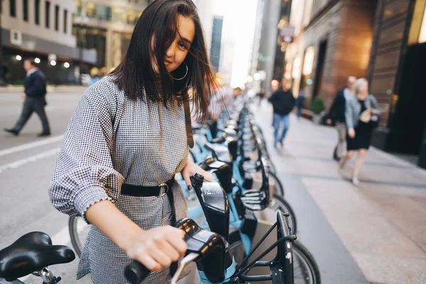 Ragazza che noleggia una bici da città da un portabiciclette — Foto Stock