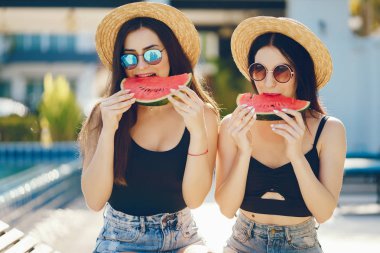 İki kız karpuz yiyor.