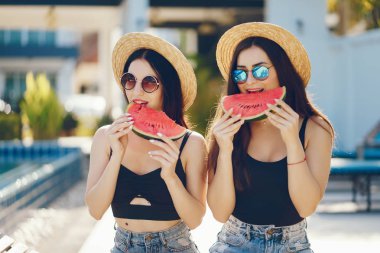 İki kız karpuz yiyor.