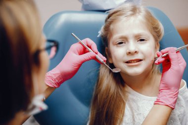 Sevimli küçük kız dişçi ofisinde oturuyor