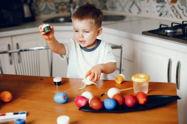 Küçük çocuk mutfakta oturuyor.