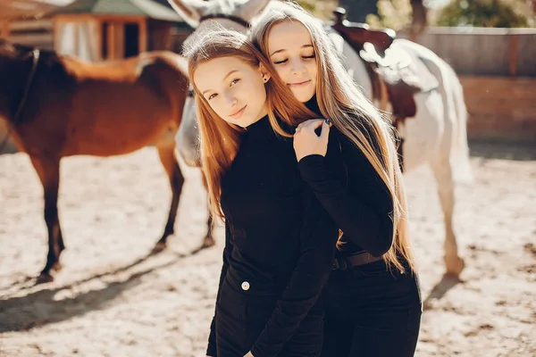 Elegante meisjes met een paard in een ranch — Stockfoto