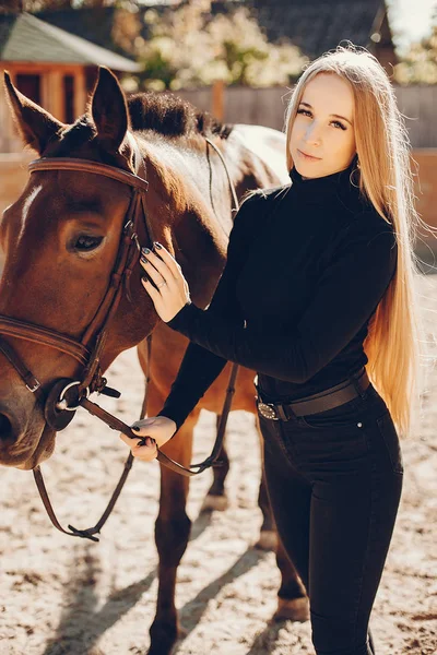 Elegants meisje met een paard in een ranch — Stockfoto