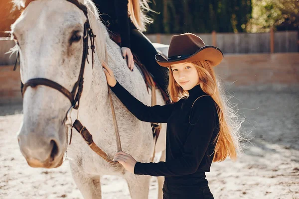 Elegante chica con un caballo en un rancho — Foto de Stock
