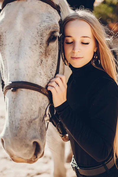 Elegants meisje met een paard in een ranch — Stockfoto