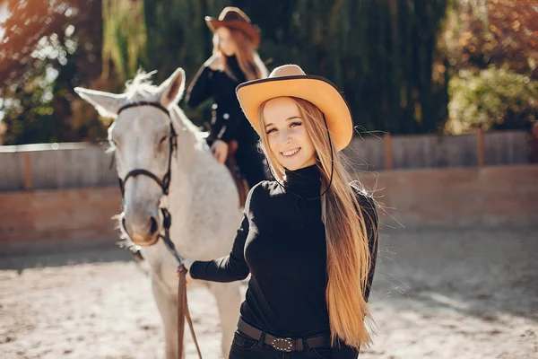 Elegante meisjes met een paard in een ranch — Stockfoto