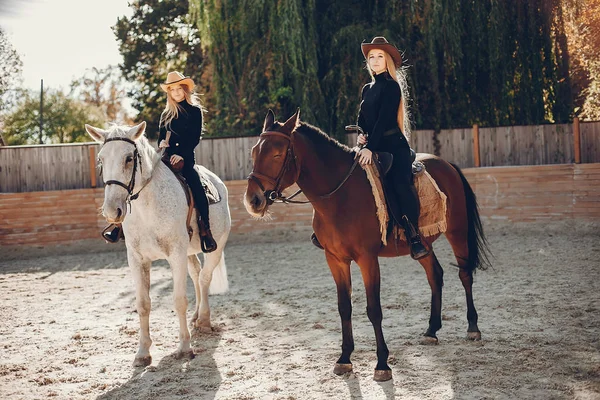 Elegante meisjes met een paard in een ranch — Stockfoto