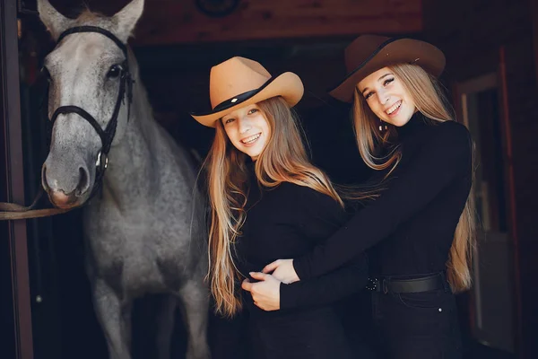 Elegante meisjes met een paard in een ranch — Stockfoto