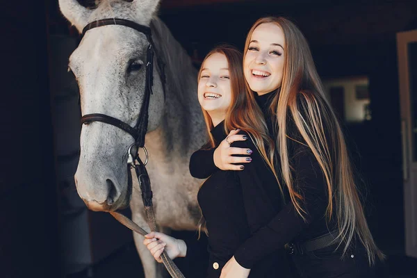 Filles élégantes avec un cheval dans un ranch — Photo