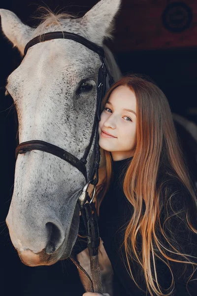 Elegants meisje met een paard in een ranch — Stockfoto