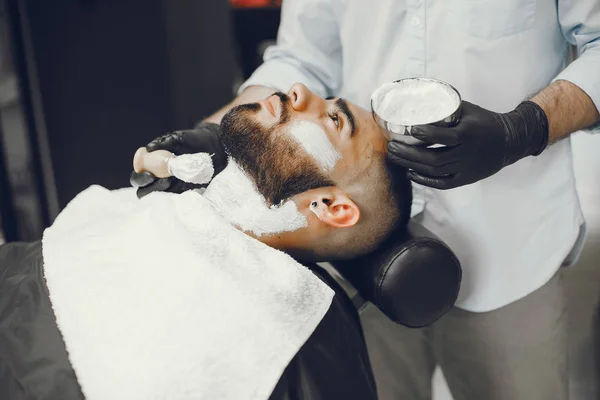 O homem corta a barba na barbearia — Fotografia de Stock