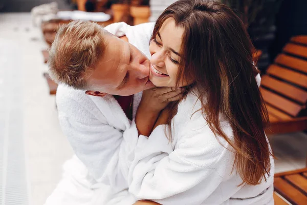 Elegant couple sitting near a swimmingpool — Stock Photo, Image