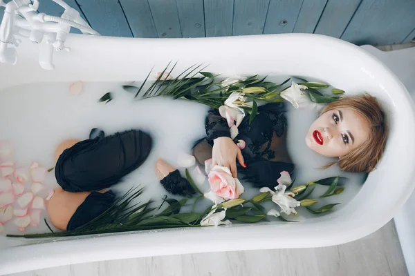 Stijlvol en mooi meisje ligt in de badkamer — Stockfoto