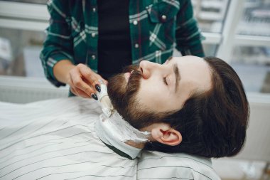 Berber dükkanında oturan şık bir adam.