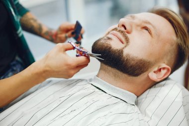 Berber dükkanında oturan şık bir adam.