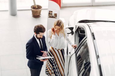 Bir araba galerisinde şık ve zarif bir kadın.