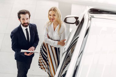 Bir araba galerisinde şık ve zarif bir kadın.