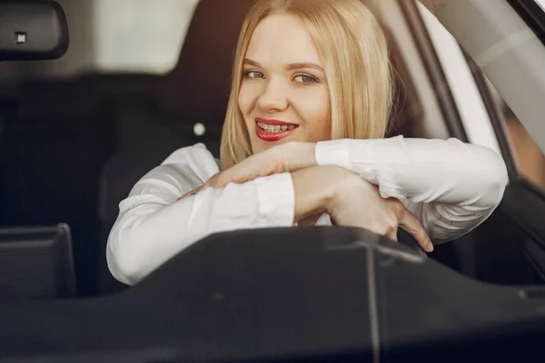 Elegante ed elegante donna in un salone di auto — Foto Stock