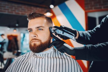 Berber dükkanında oturan şık bir adam.